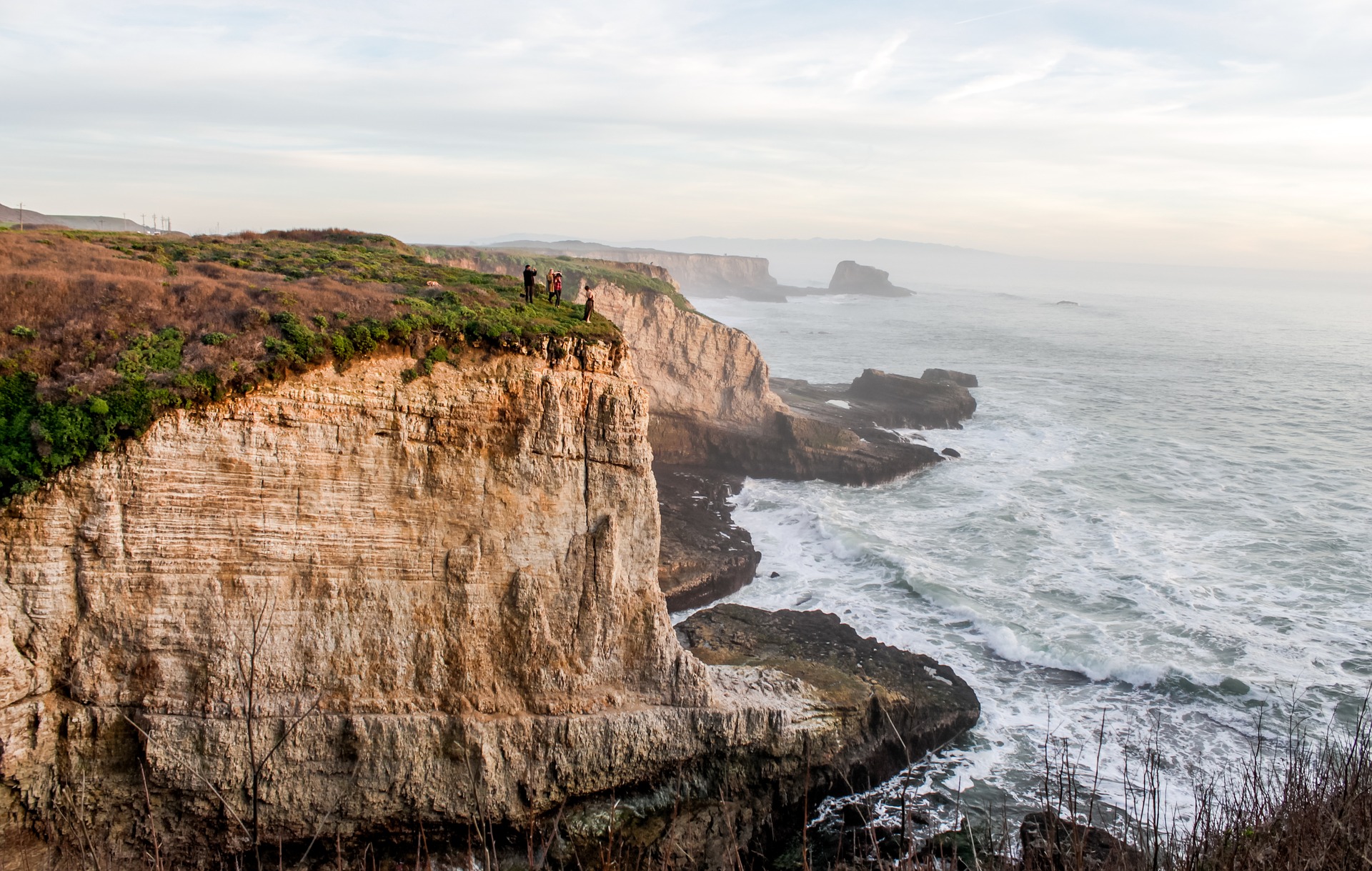 Tourists stand on a cliff in Santa Cruz