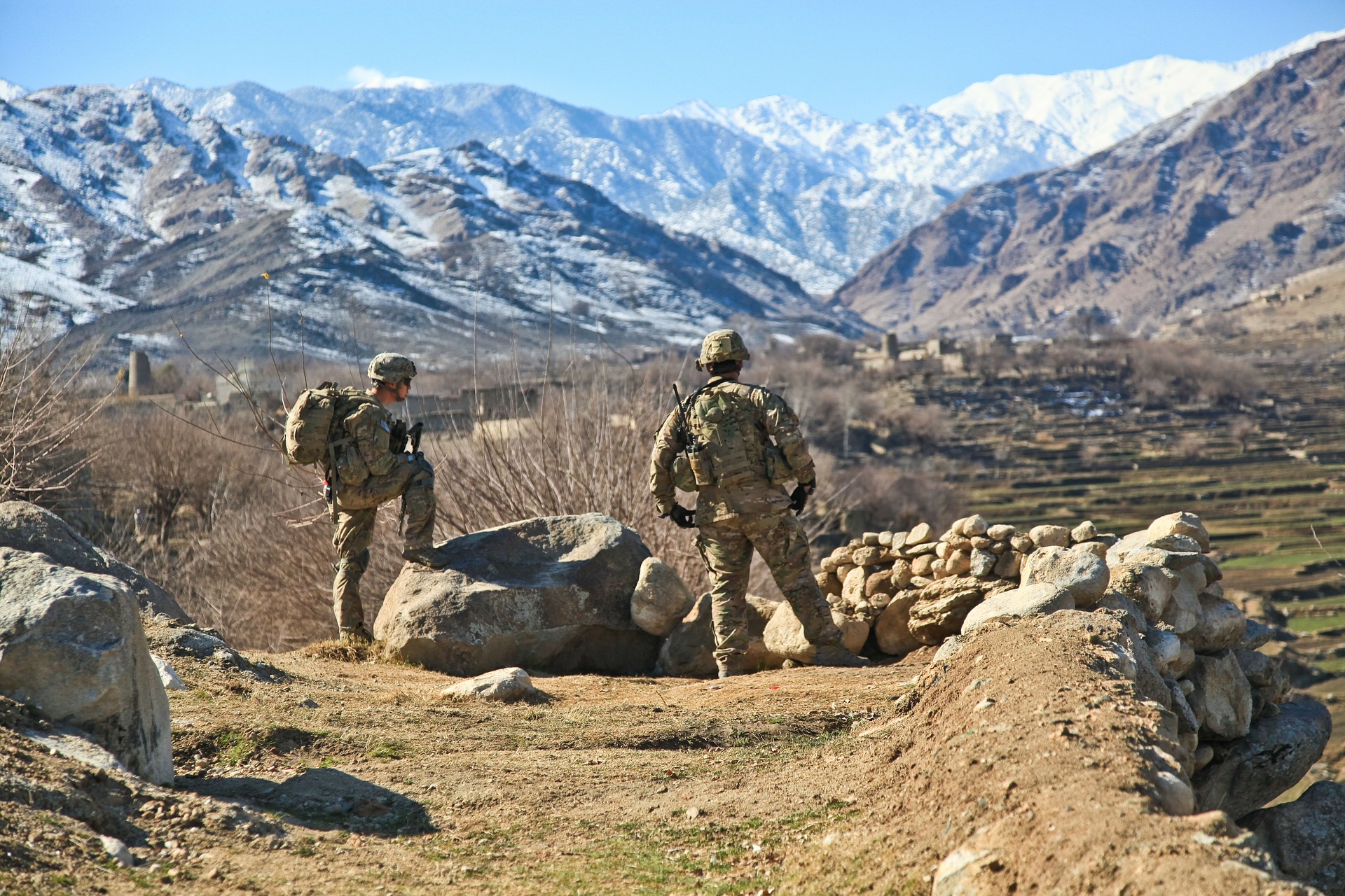 Two soldiers stand on a rocky mountain scape