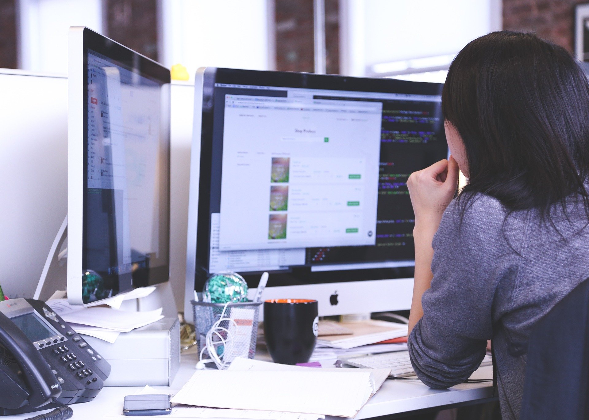 A woman works on a mac computer